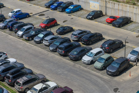 August 13, 2026, Tbilisi, Georgia An elevated, wide-angle overhead view of a large, neatly organized outdoor parking lot featuring numerous vehicles of different makes, models, and colors parked across concrete and grid-paved bays.