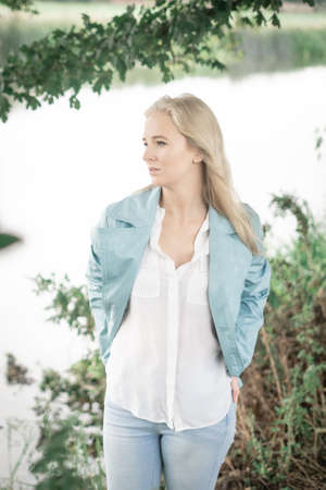 Thoughtful Woman In Front Under A Tree By A Riverの写真素材