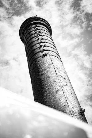 A Water Tower Rises Up Against A Cloudy Sky, Portrait Orientationの写真素材