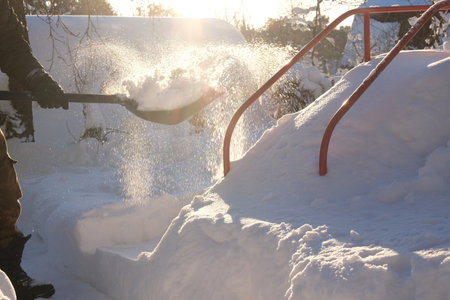 Snow removal with a shovel in the yardの写真素材