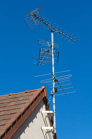 Roof and tv antenna by blue skyの写真素材
