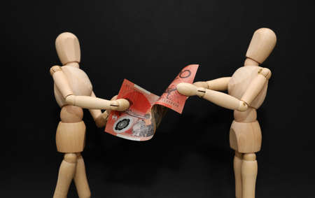 A pair of wooden mannequins talking discussing fighting arguing over financial strain pressure...