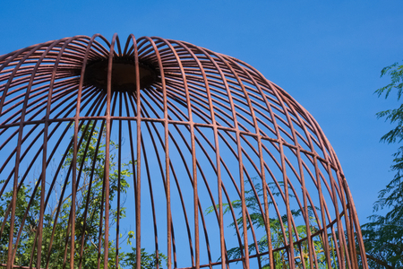 Rustic domed cage protecting gardening supplies in a beautiful garden park in Bangkok, Thailand.の写真素材
