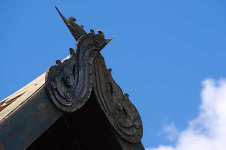 An interesting ancient Siam architectural feature, placed at the apex of a roof's arch of an old Thai structure, in Bangkok, Thailand.の写真素材