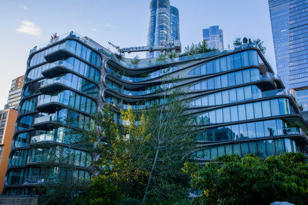 A striking image of a futuristic residential building with curved glass balconies, captured from the...