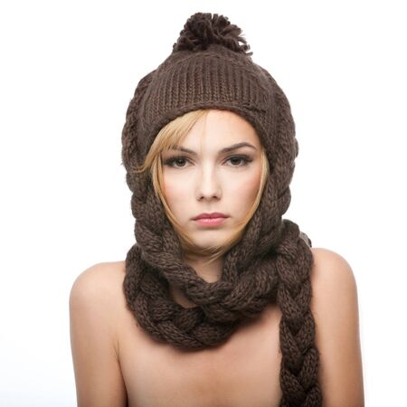 a portrait of a young, blonde woman, with a brown winter hat on her headの写真素材