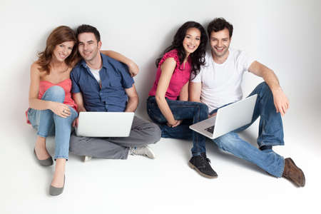 group of carfree beautiful friends with laptopsの写真素材