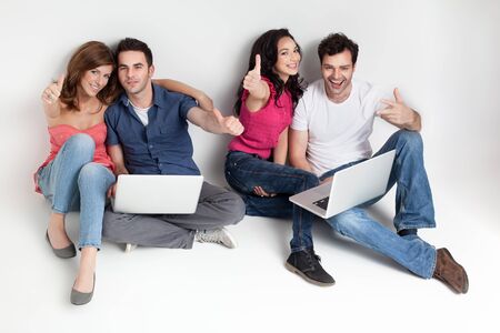 young group happy friends hoding aprooving laptopsの写真素材