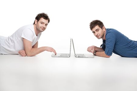 young men posing at camera in front of laptopsの写真素材