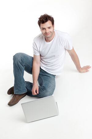 man sitting behind blanck laptop smilingの写真素材