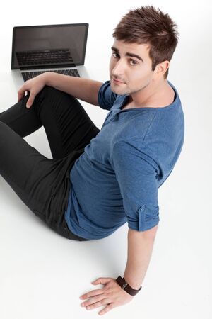 handsome man with laptop looking over sholderの写真素材