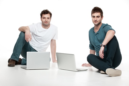 two handsome men sitting with laptopsの写真素材