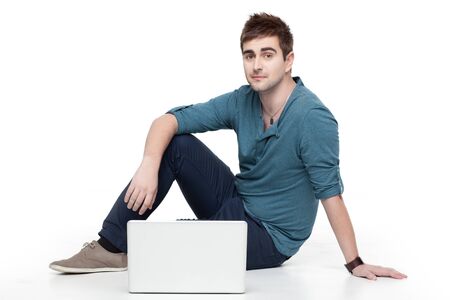 handsome man sitting comfortable behind laptopの写真素材
