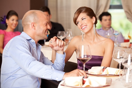 young smiling couple romancing at a restaurant table の写真素材