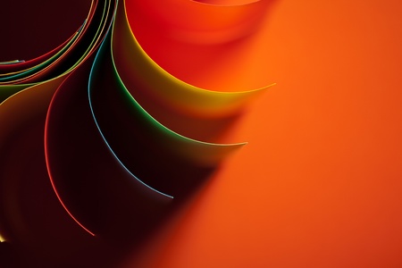 macro image of colorful curved sheets of paper shaped like a flower, on orange backgroundの写真素材