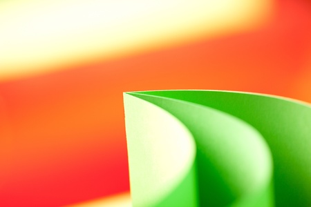 background macro image of colorful origami fan pattern made of curved sheets of paper, on orange backgroundの写真素材