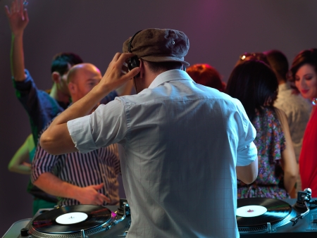 dj entertaining the happy, dancing crowd in a night clubの写真素材
