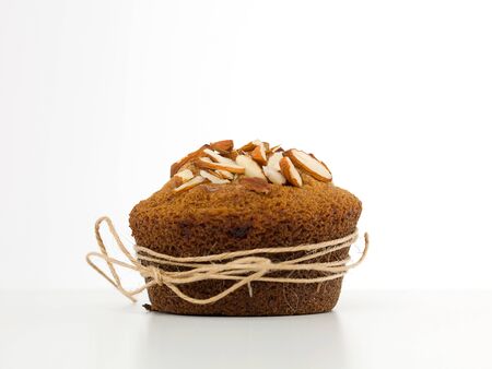 closeup of an almond muffin, wrapped with a string, with a bow, on a white backgroundの写真素材