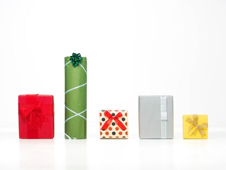 different shaped colorful presents in a row with pretty deorations isolated on white background, cut...