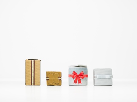 closeup of four different presents in a row with beautiful and elegant decorations isolated on whiteの写真素材