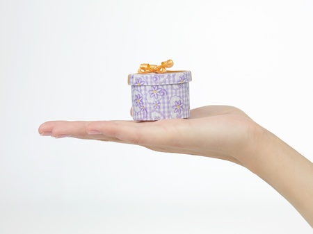 Outstretched hand with a small gift in hand
