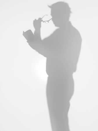 young male reading a book with glasses の写真素材