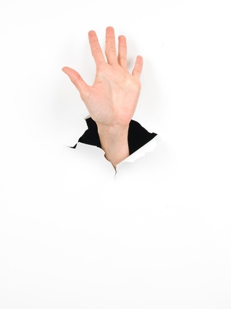 close-up of female hand coming out from a hole in a paper, high five gesture, isolated on whiteの写真素材