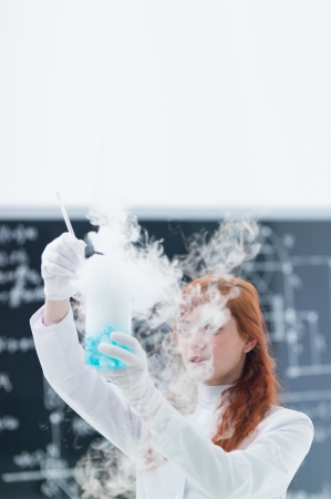 general-view of a student in a chemistry lab conducting an experiment with gas and colorful liquidsの写真素材