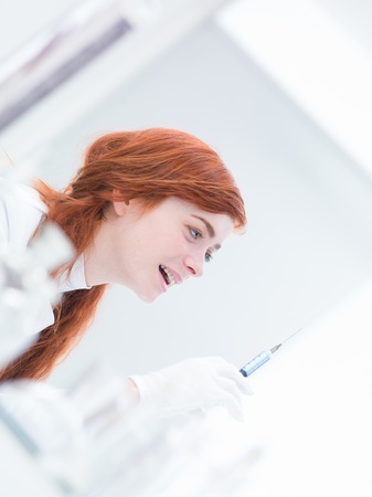 close-up of a woman  in a laboratory  preparing an injection and being happyの写真素材