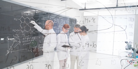 close-up  seen trough a transparent board in a chemistry lab of people analyzing informationの写真素材