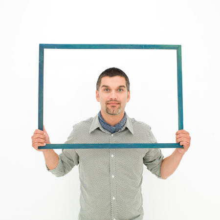 caucasian man holding an empty frame in front of himの写真素材