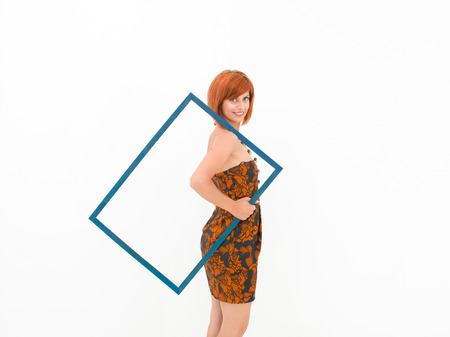 side view of beautiful caucasian woman holding on her shoulder an empty frame