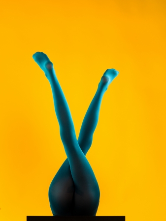 woman wearing blue stockings lying on her back with her legs up, crossed, making an x shapeの写真素材