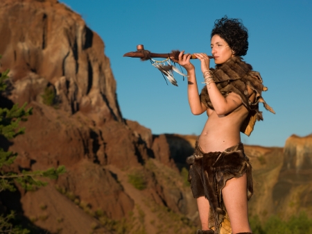 woman wearing primitive fur clothes smoking from a peace pipe in natureの写真素材