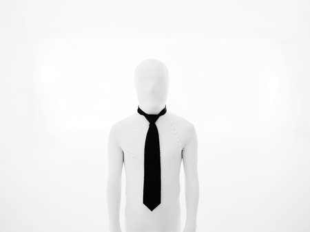 faceless white businessman standing straight, wearing a black tieの写真素材