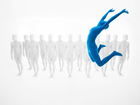 Woman dressed in blue suit jumps up in front of a group of white peopleの写真素材