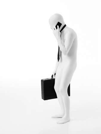 Hunched faceless businessman dressed in white, wearing tie, holding black briefcase talking on the phoneの写真素材