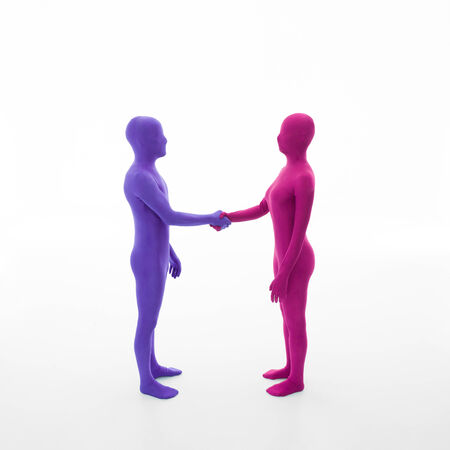 unrecognizable man dressed in purple shakes hands with faceless woman dressed in pink の写真素材