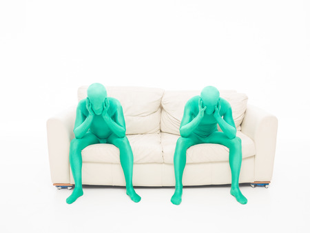 two people sitting on the couch, thinking, hands on headの写真素材