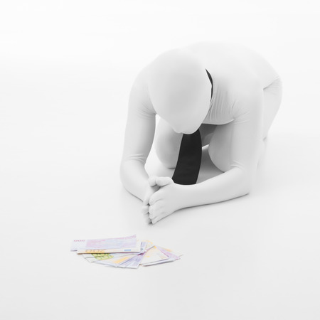 man dressed in white with black tie prays to moneyの写真素材