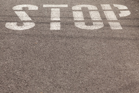stop sign painted on asphaltの写真素材