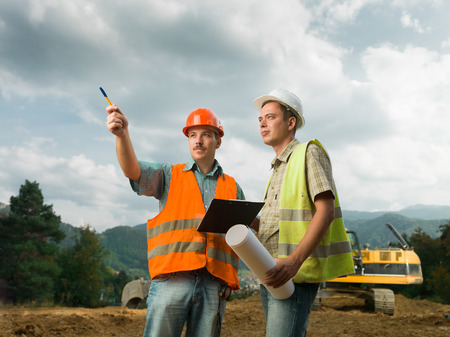 two coworkers on construction site outdoors discussing