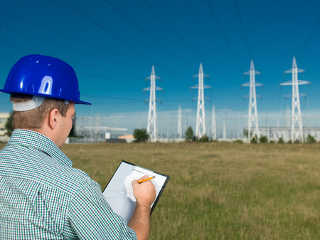 portrait of male technician writing on clipboard at electricity stationの写真素材