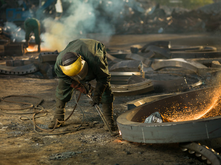 worker with protective equipment welding metalの写真素材