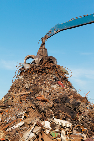 crane holding rusty metal in recycling junkyardの写真素材