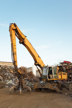 side view of crane in junkyard with clear blue skyの写真素材