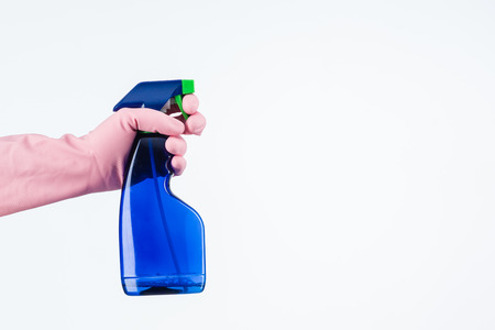 human hand with protective glove holding cleaning spray bottle. isolated on whiteの写真素材