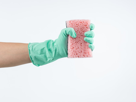 human hand with green rubber gloves holding pink sponge on white backgroundの写真素材