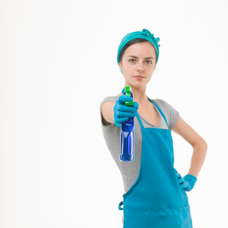 portrait of cleaning woman aiming spray bottle in front of her, on white backgroundの写真素材