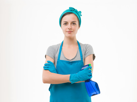 portrait of young maid holding cleaning spray bottle, isolated on white backgroundの写真素材